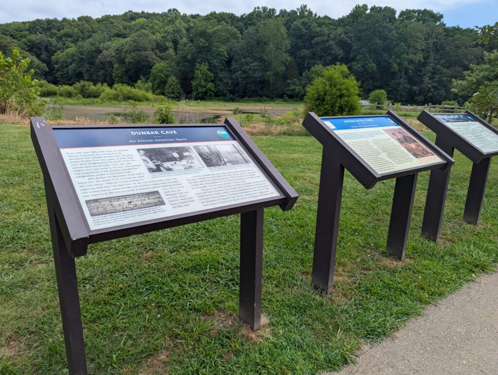 Wayfinding signs along a paved path at Dunbar Cave State Park